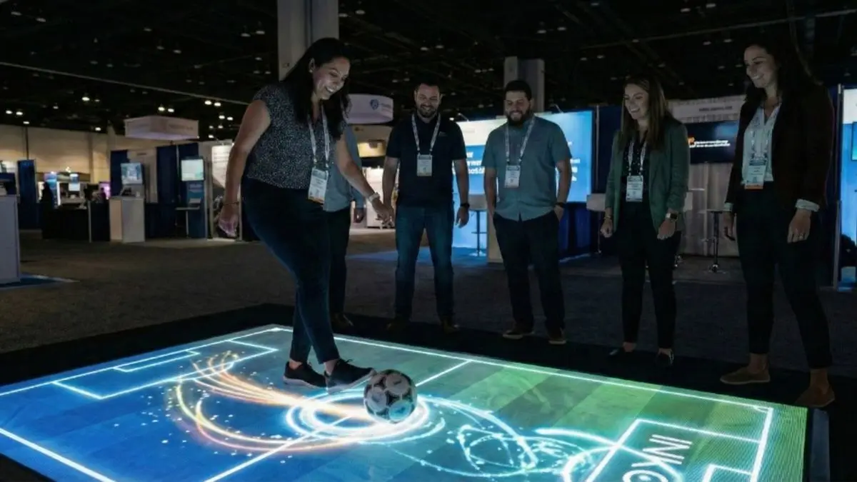 Piso interactivo con proyección y balón en una exposición